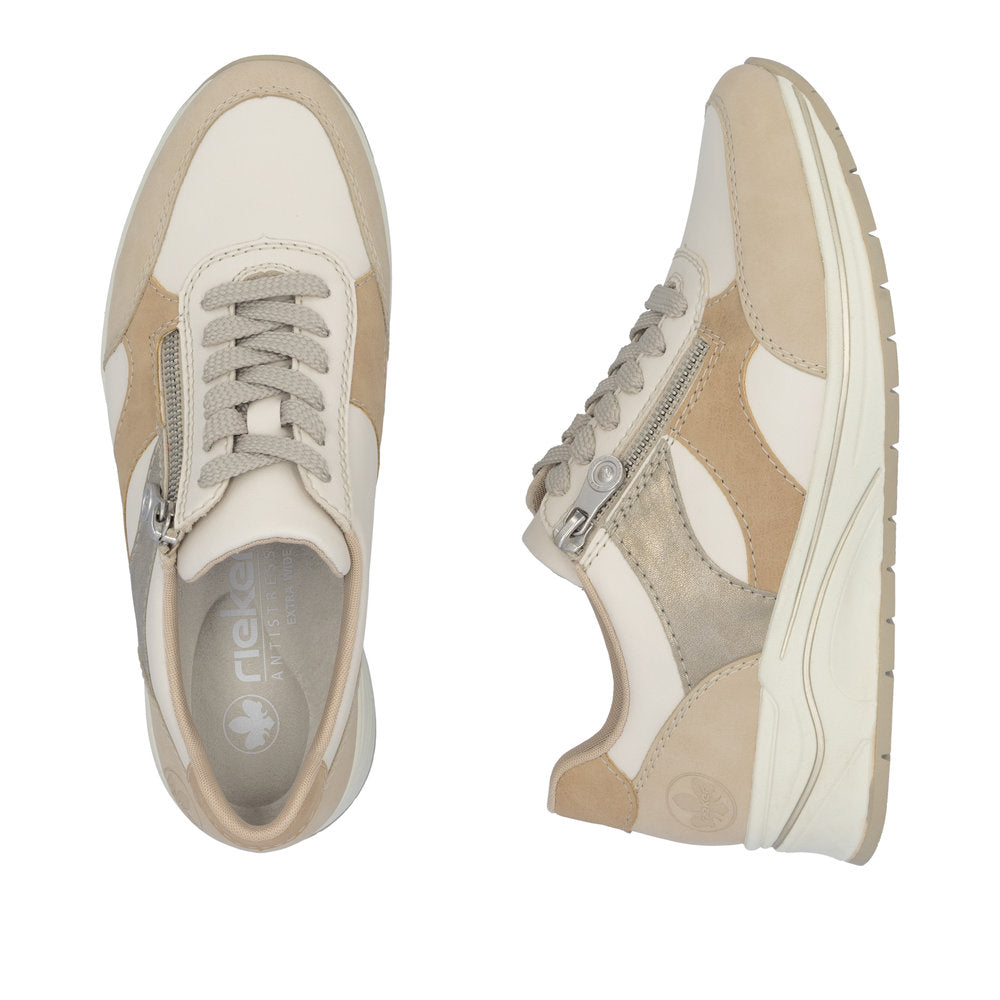 Rieker N9518-60 women's wide-fit lace-up trainers with multi-zip design, beige and cream color, and side zipper detailing.