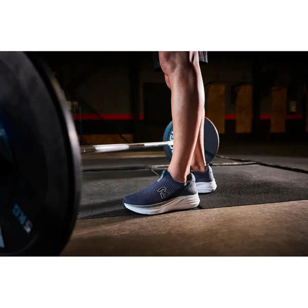 Rieker U4100-14 men's wide-fit blue textile slip-on shoes in a gym setting, showcasing sporty comfort and casual style.