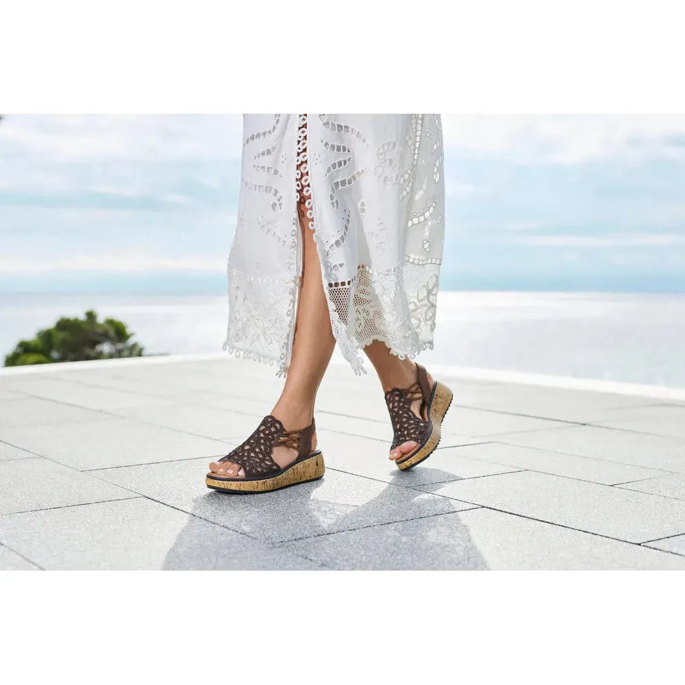 Rieker V1765-24 women's wide brown elasticated sandals with a crochet design and cork wedge sole, ideal for summer wear.