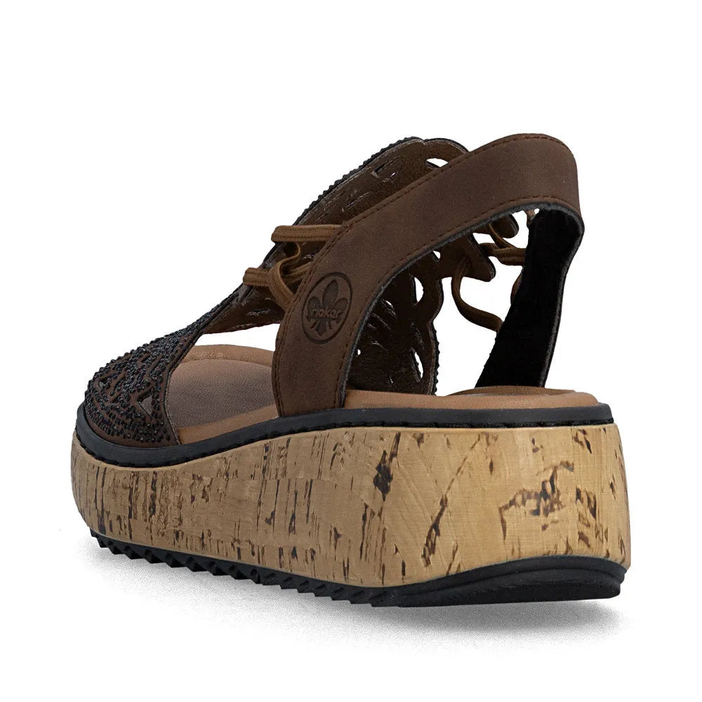 Rieker V1765-24 women's wide-fit brown elasticated sandals with a chunky cork platform sole and decorative cutouts.