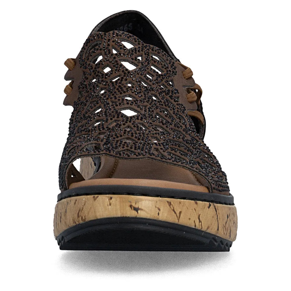 Rieker V1765-24 women's wide brown elasticated sandals with intricate cutout design and black embellishments, featuring a cork-style platform sole.