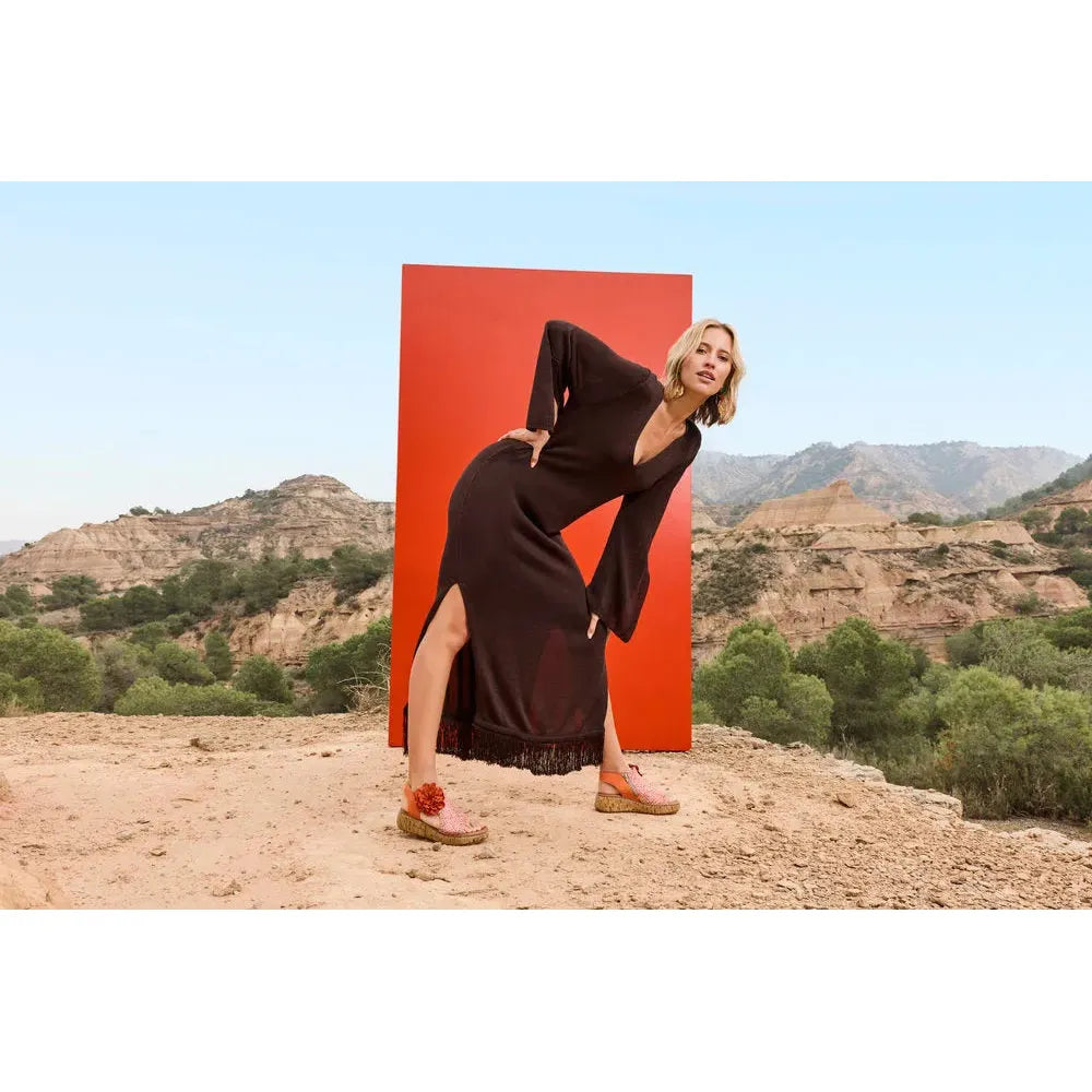 Rieker V1783-90 women's pumpkin orange textile side-zip sandals on model outdoors with desert landscape background.