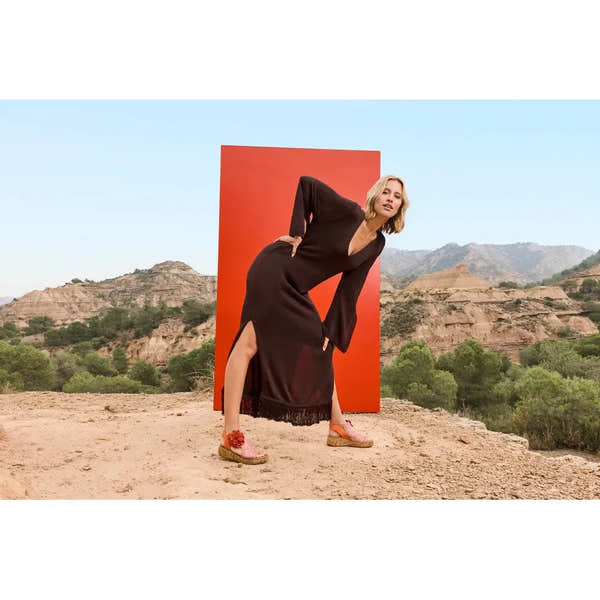 Rieker V1783-90 women's pumpkin orange textile side-zip sandals on model outdoors with desert landscape background.