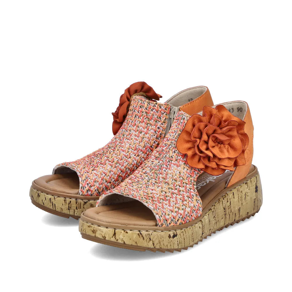 Rieker V1783-90 women's pumpkin orange textile slide sandals with side zips, floral details, and cork platform sole.