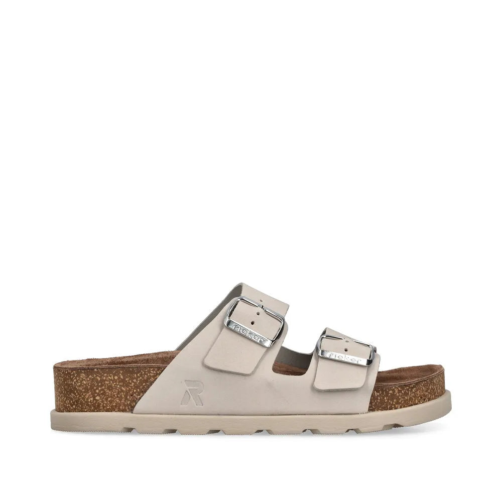 Rieker V3190-40 women's off-white leather buckle mules with dual straps and cork footbed.