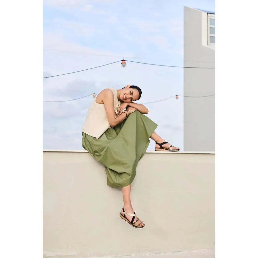 Rieker V3663-92 ladies multi-touch fastening sandals, black and beige open-toe design, worn by woman sitting on wall outdoors.