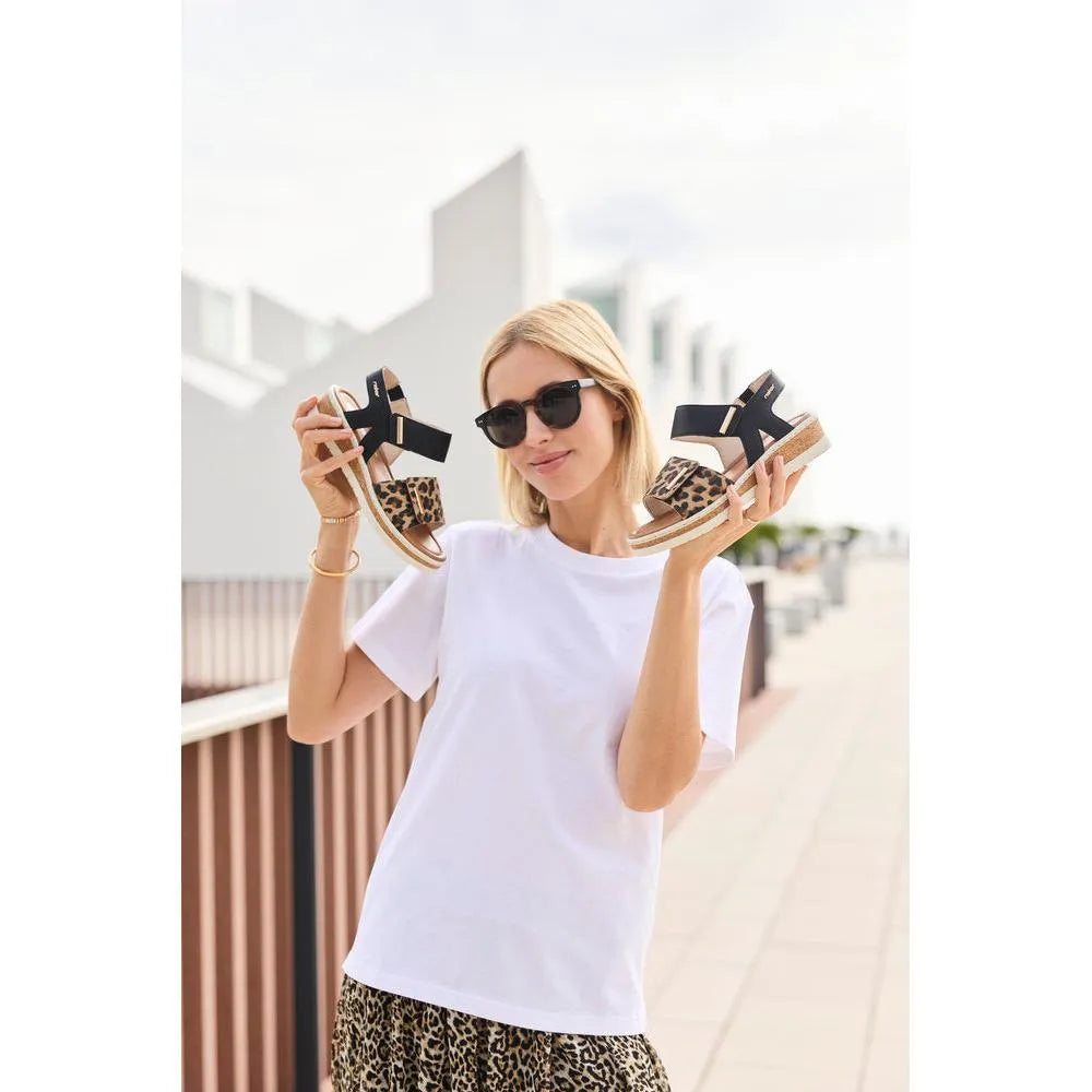 Rieker V4181-00 women's wide fit multi-touch fastening sandals with leopard print accents and chunky heel, outdoor urban setting.