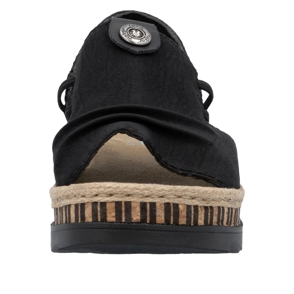 Black slip-on sandal with a cork and espadrille wedge heel, side laces, and a rounded toe, featuring a textured upper and metal detail.