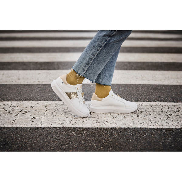 Rieker W1202-82 women's white and metallic leather lace-up trainers with gold accents, casual sneaker style, on a street crosswalk.