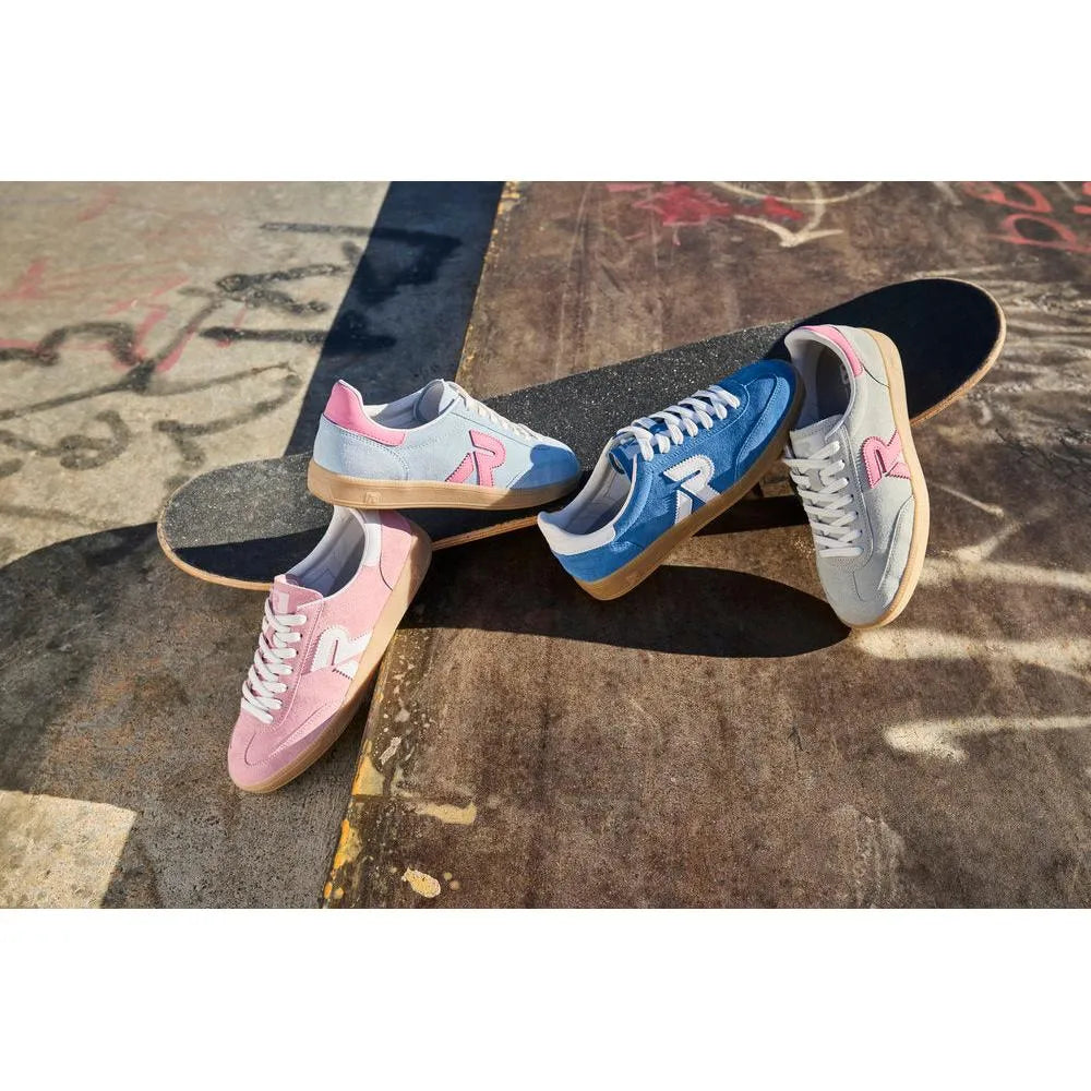 Light blue and pink suede lace-up trainers with gum soles, featuring a large 