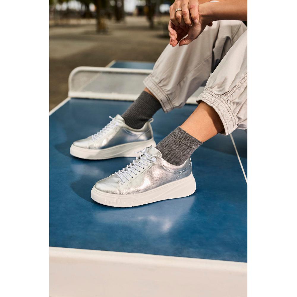 Rieker W2301-90 ladies silver leather lace-up sneakers with chunky white soles and grey socks, stylish and comfortable footwear.