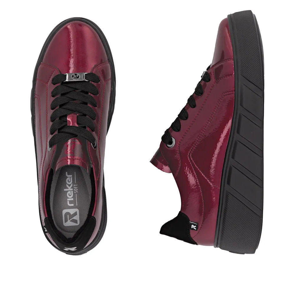 Red patent leather lace-up trainers for women, lightweight Rieker W2601-35 casual sneakers with black laces and sole.