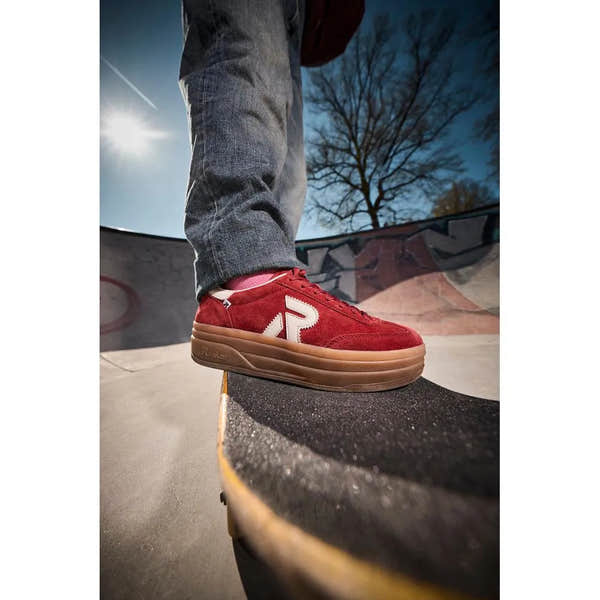 Rieker W3700-35 women's red suede lace-up trainers on skateboard at skatepark, casual lifestyle footwear.