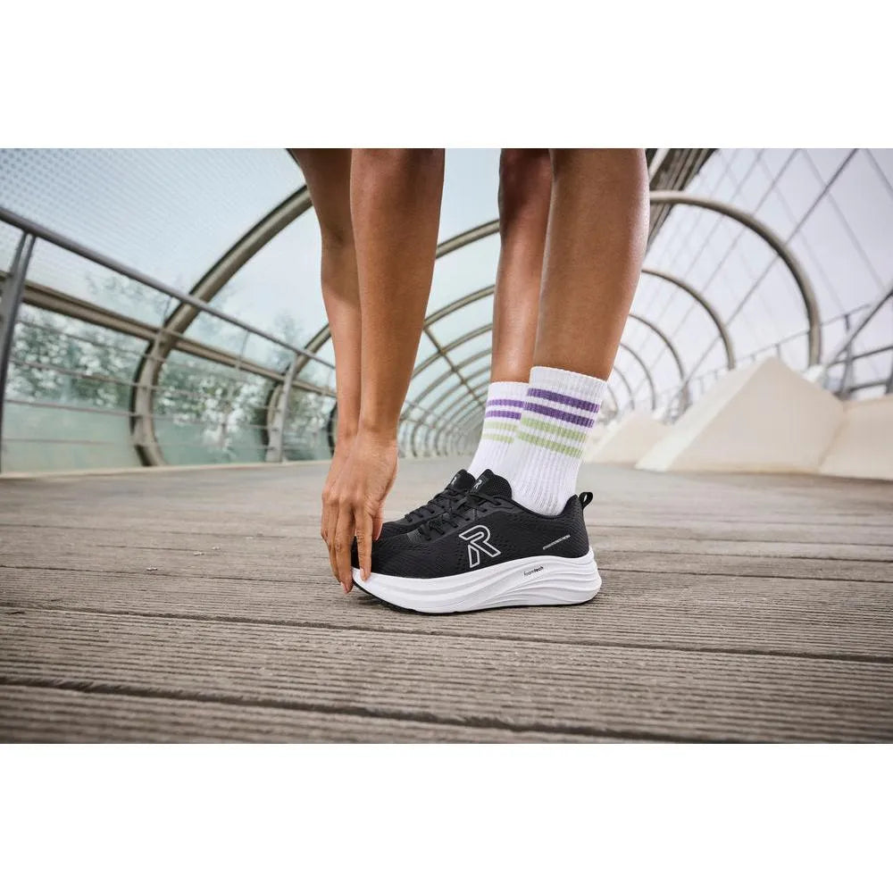 Black textile lace-up trainers with white sole, model W4101-00, worn with colorful striped socks.