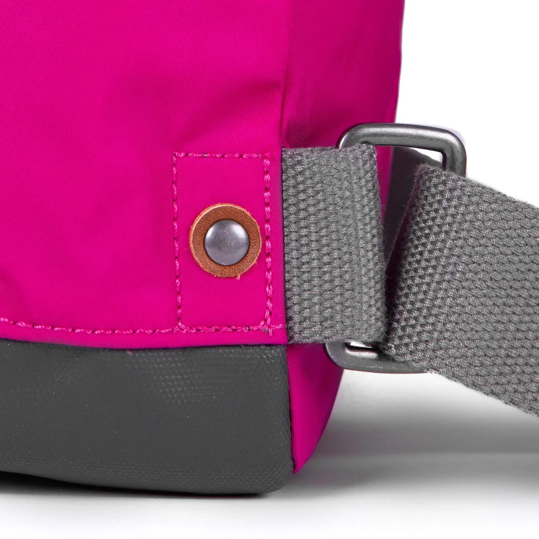 Roka Bantry B Candy backpack made from recycled nylon, featuring pink fabric, gray strap, and metal buckle. Eco-friendly and stylish.