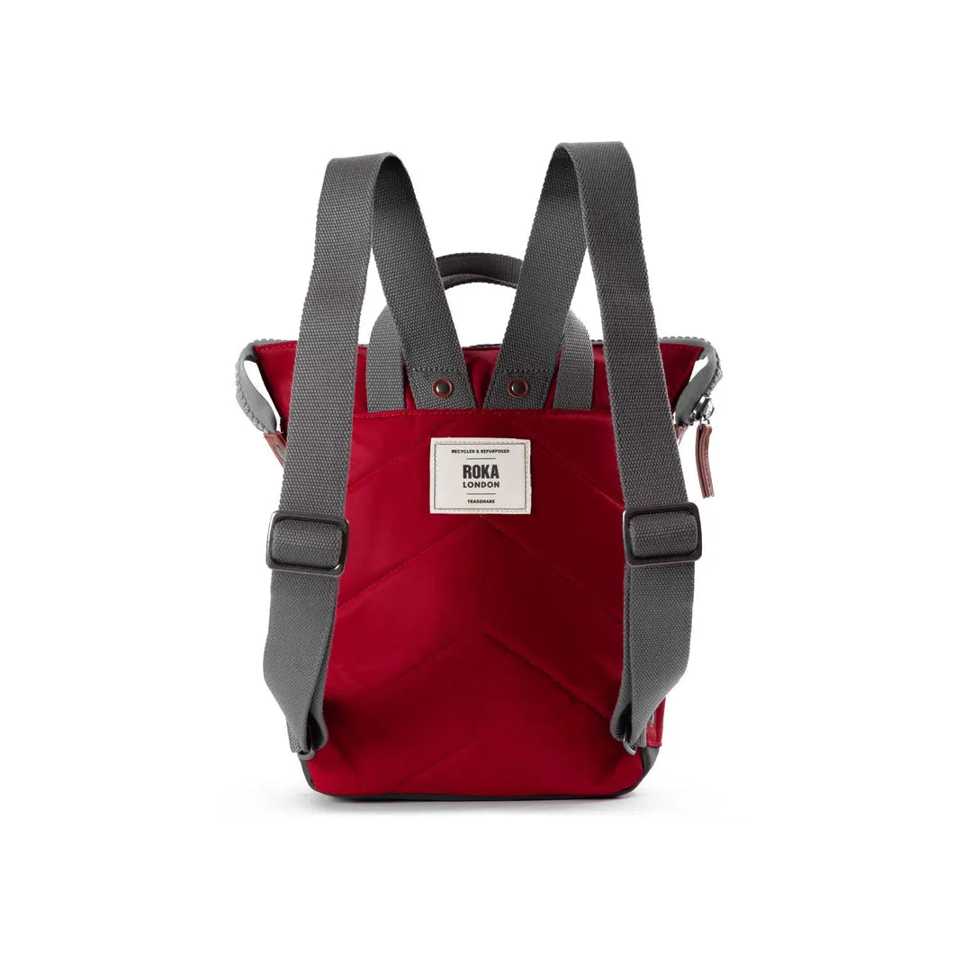 Roka Bantry B cranberry recycled nylon backpack with gray adjustable straps and front logo patch. Sustainable, stylish everyday bag.