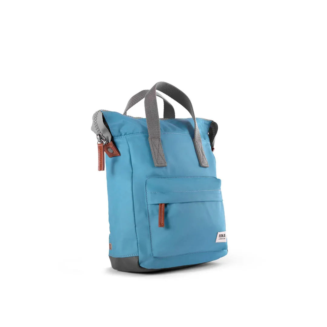 Roka Bantry B backpack made from recycled nylon, blue color with gray handles and brown zipper accents, eco-friendly travel bag.