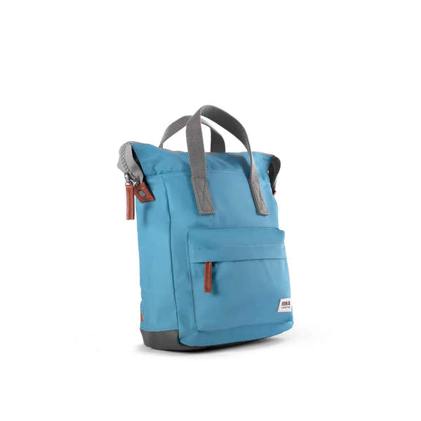 Roka Bantry B backpack made from recycled nylon, blue color with gray handles and brown zipper accents, eco-friendly travel bag.