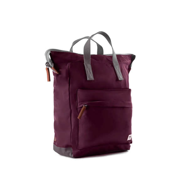 Roka Bantry B backpack made from recycled nylon, plum color, with front zip pocket, grey handles, and durable design.
