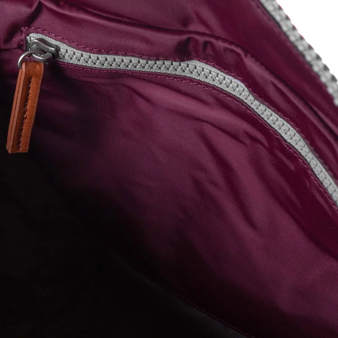 Roka Bantry B Plum recycled nylon backpack interior with zippered pocket and leather pull tab, eco-friendly and stylish accessory.
