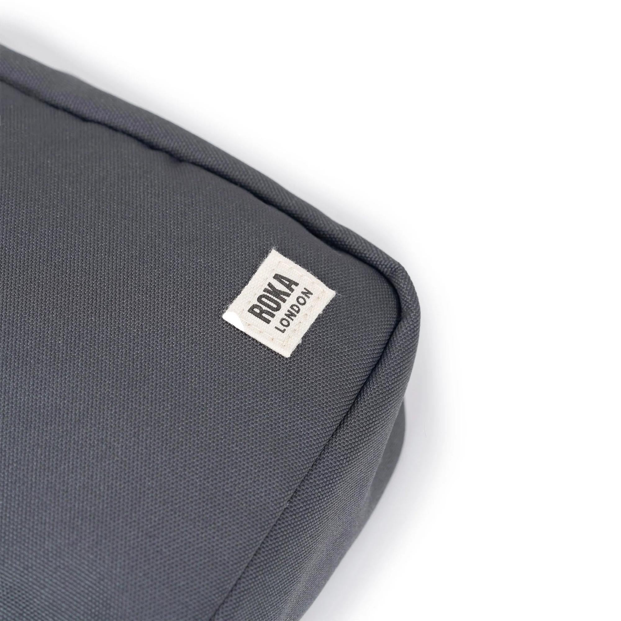 Roka Bond Faded Black recycled canvas bag, one size, with ROKA LONDON label detailing, close-up view of fabric and stitching.