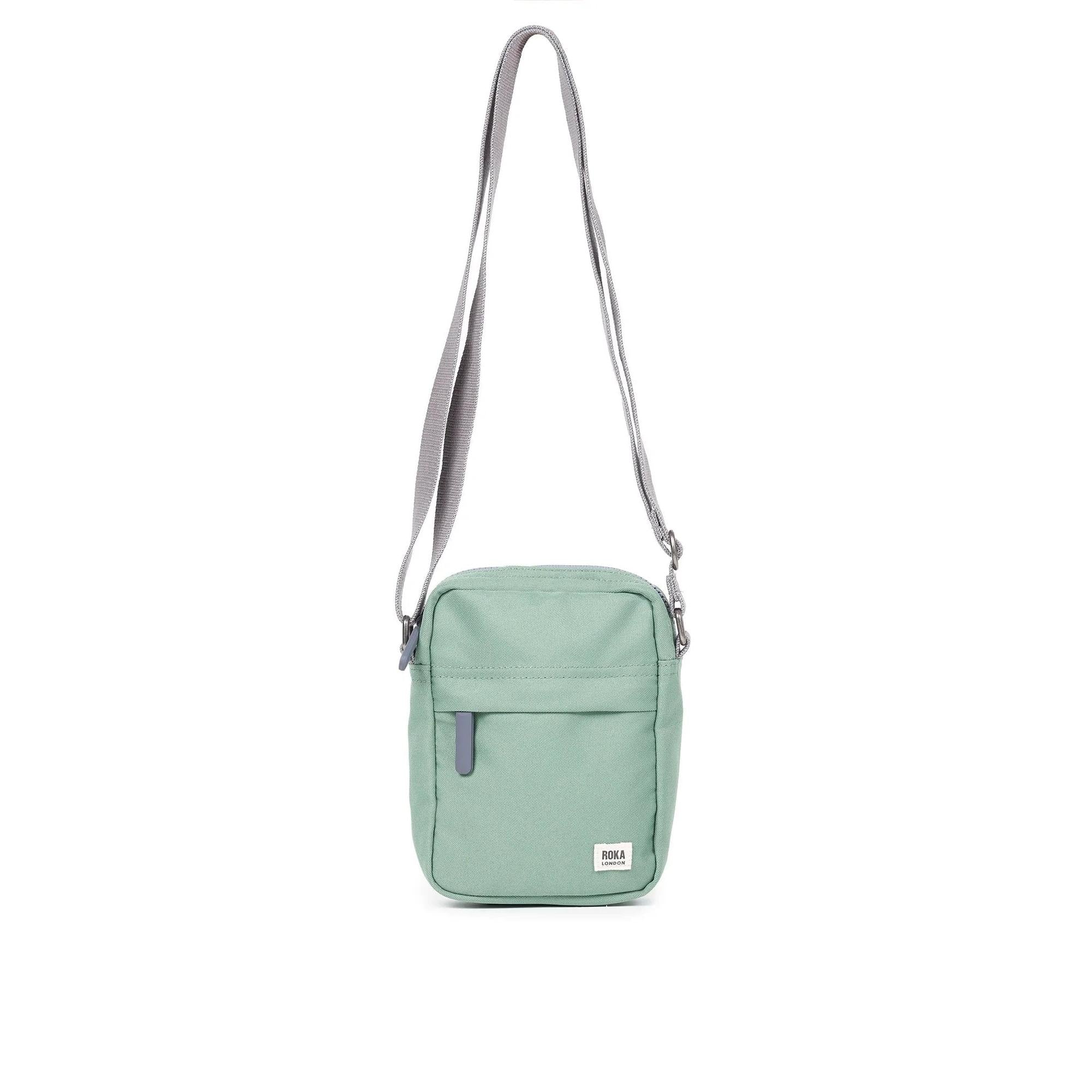 Roka Bond Frost recycled canvas crossbody bag, one size, mint green with gray adjustable strap and front zipper pocket.