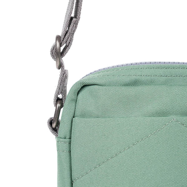 Roka Bond Frost recycled canvas bag with chain strap, one size, mint green color, close-up of corner and strap attachment.