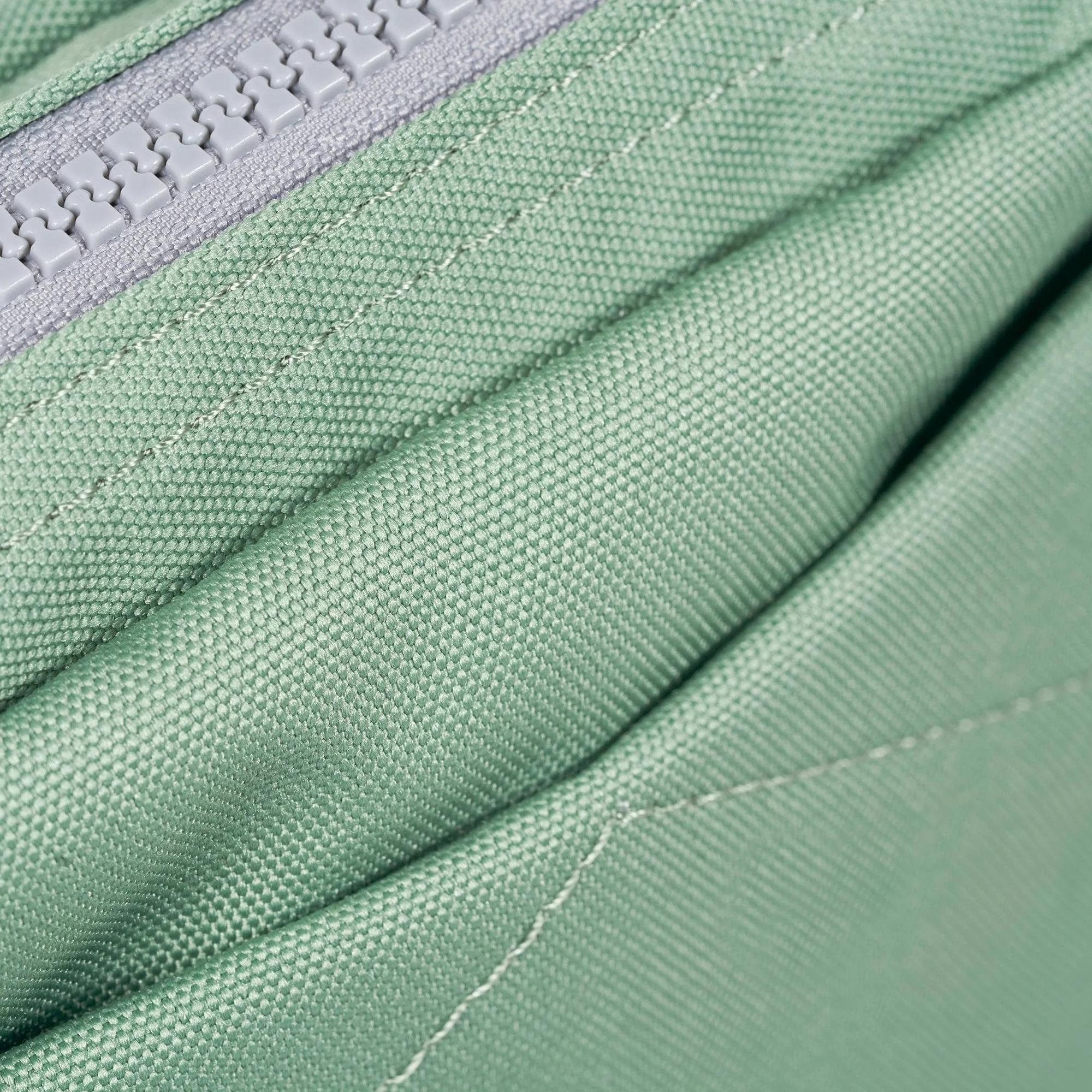 Close-up of a green recycled canvas bag with a zipper, 