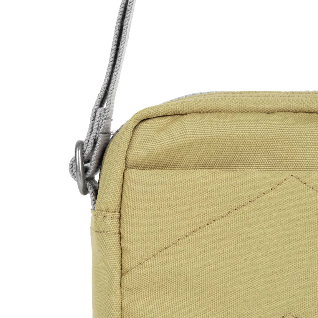 Roka Bond khaki one-size recycled canvas shoulder bag, close-up of fabric texture and strap detail.