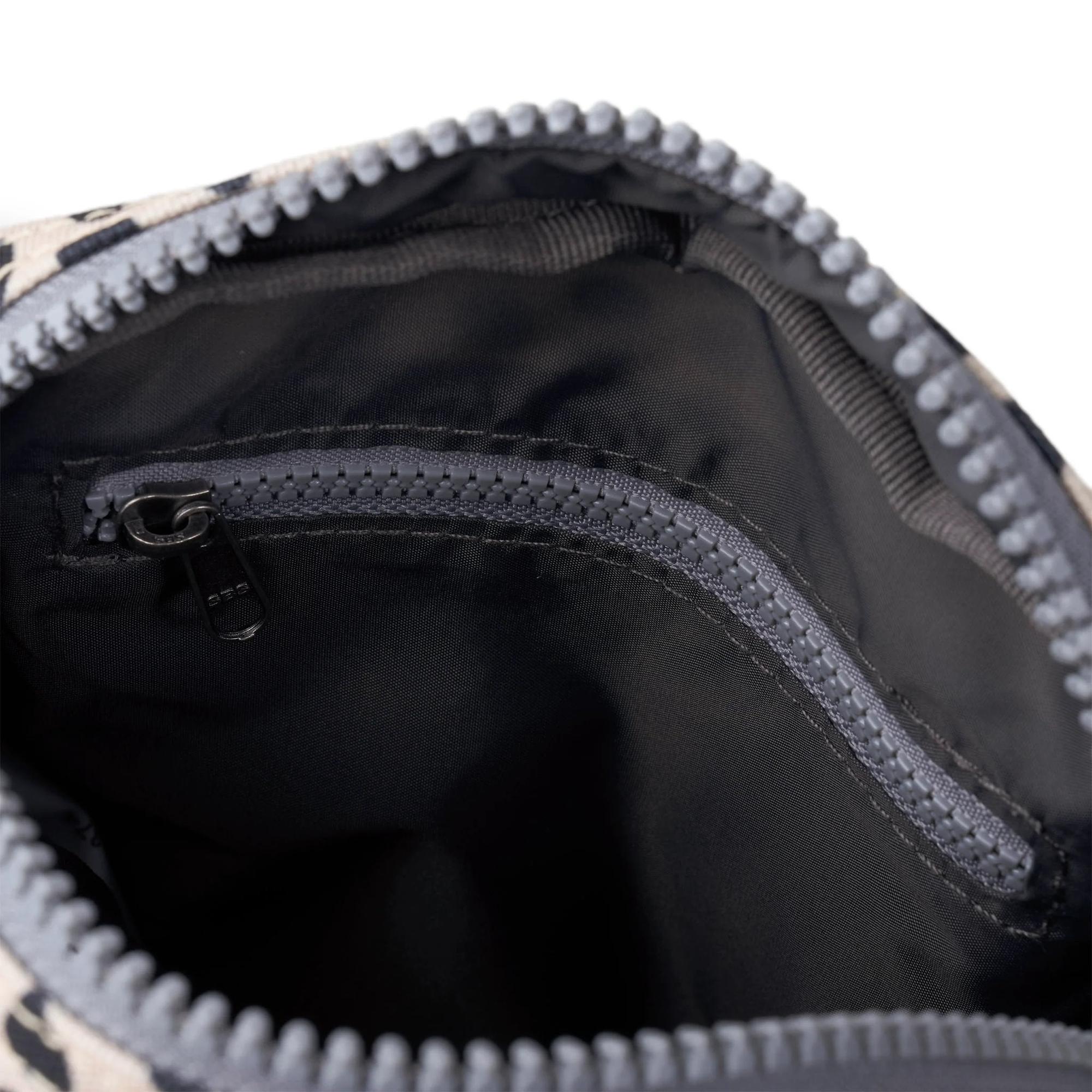 Interior view of Roka Bond linear dot recycled canvas bag with zippered pocket and black lining.