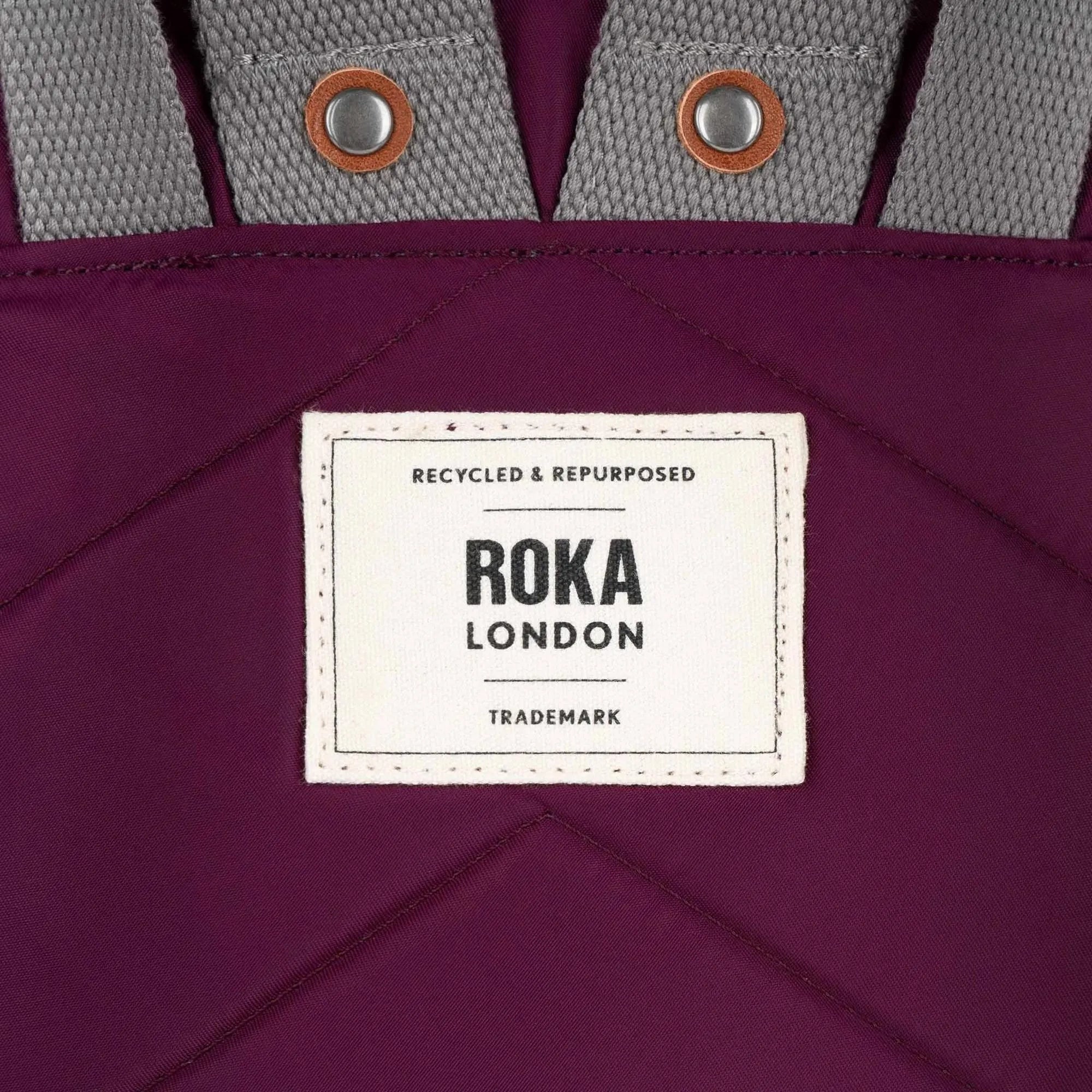 Roka Canfield B Royal Burgundy recycled nylon bag with gray straps and metal eyelets, featuring a white label.