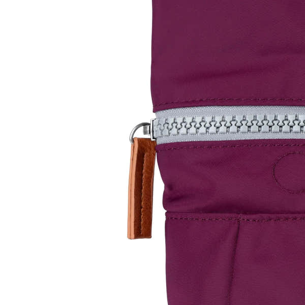 Roka Canfield B Royal Burgundy recycled nylon backpack with silver zipper and brown leather pull tab.