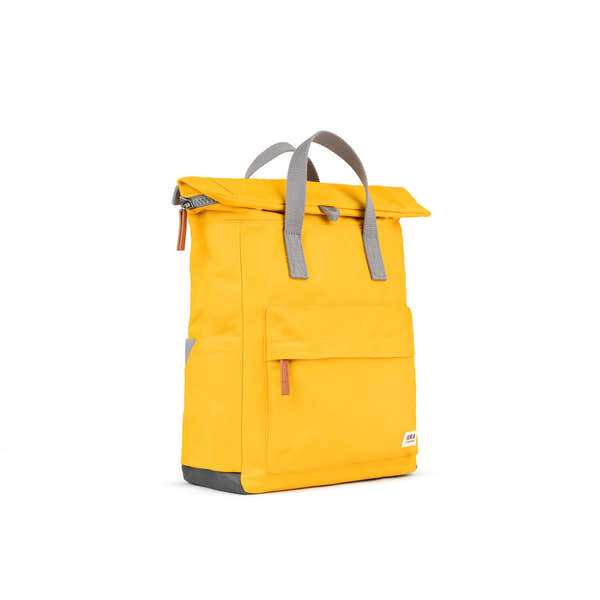 Roka Canfield B Saffron backpack made from recycled nylon, featuring a vibrant yellow color, gray handles, and multiple storage pockets.