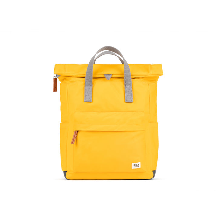 Roka Canfield backpack in saffron yellow recycled nylon with gray handles and front zip pocket.