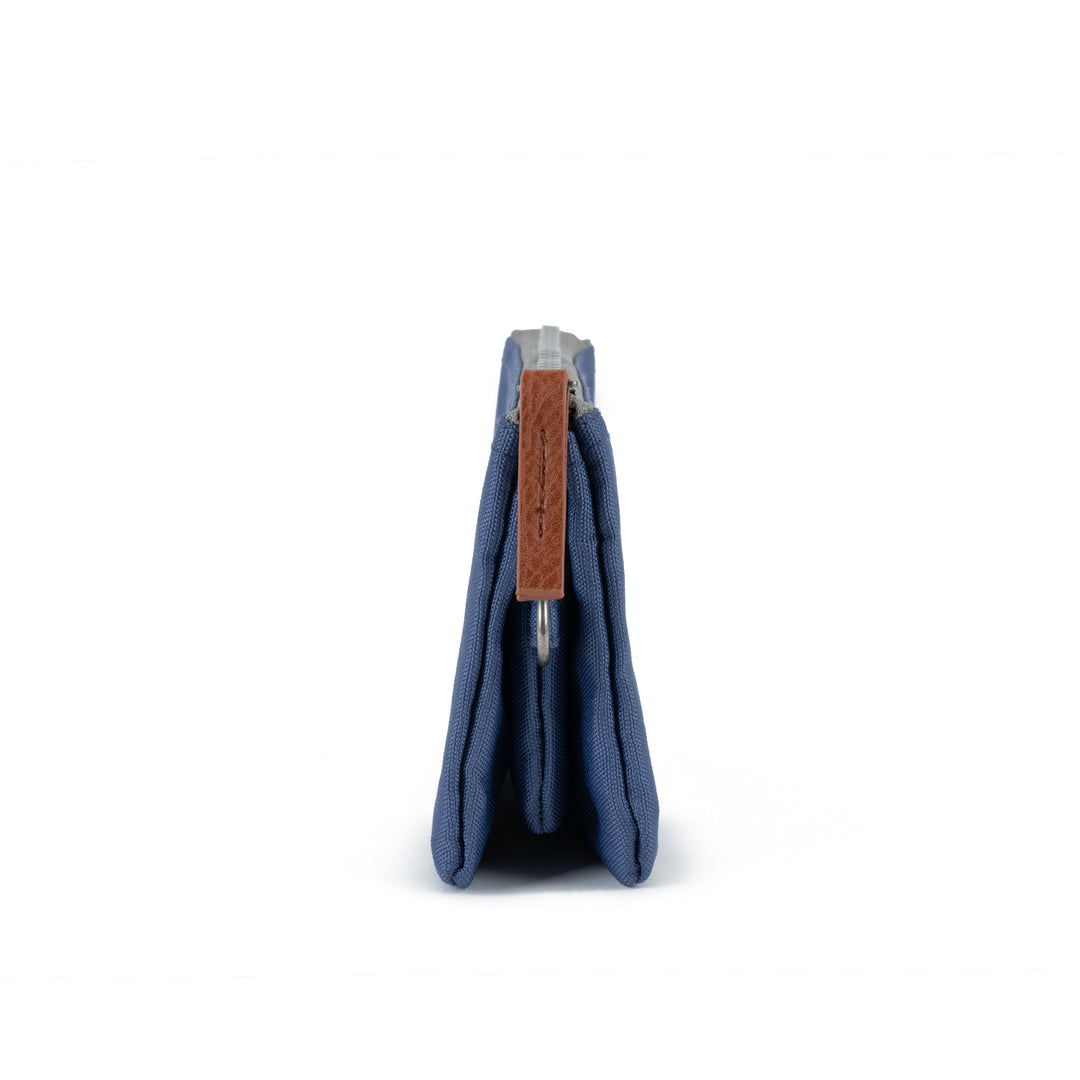 Roka Carnaby Burnt Blue Recycled Canvas wallet, side view, featuring brown leather zipper pull and compact design.