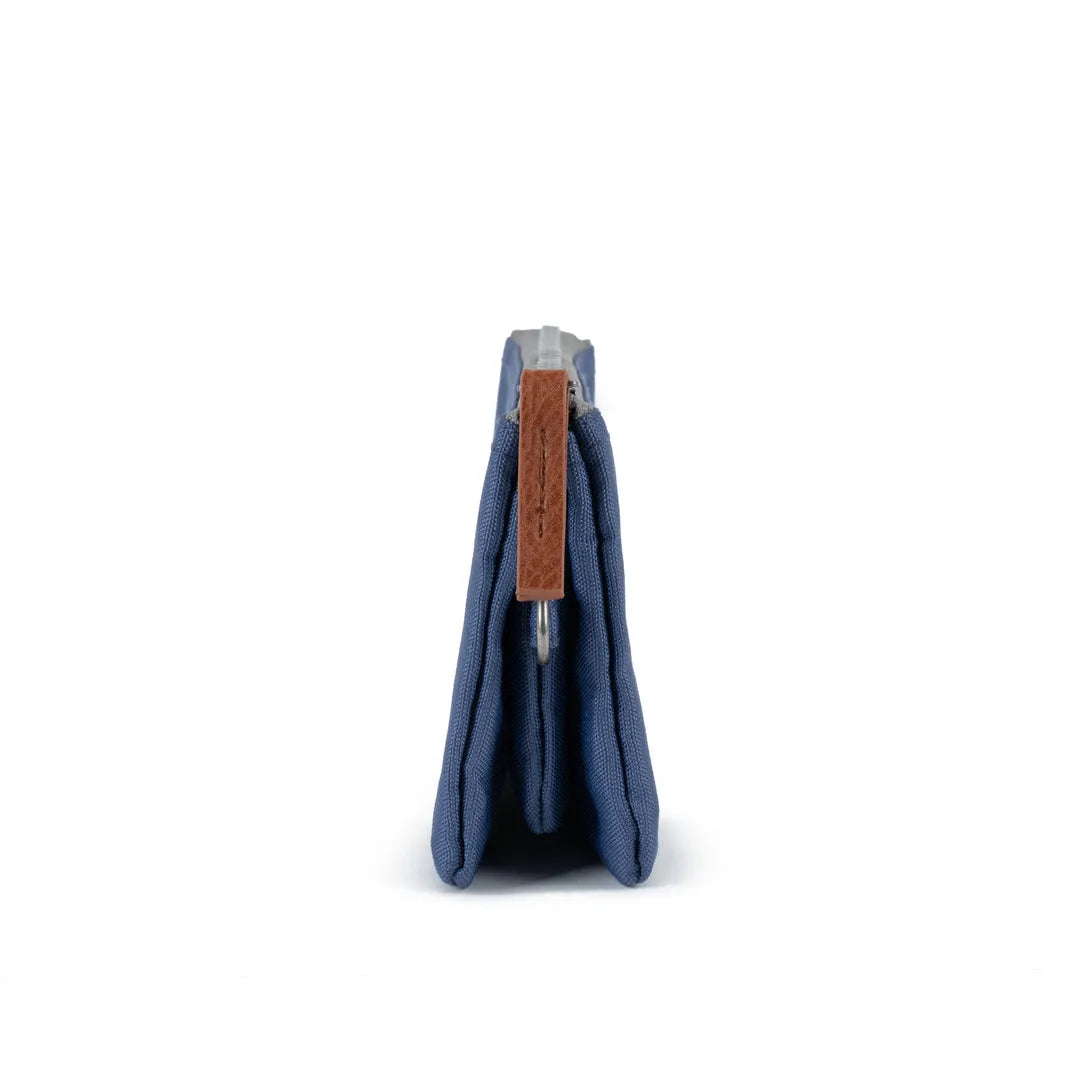 Roka Carnaby Burnt Blue Recycled Canvas wallet, side view, featuring brown leather zipper pull and compact design.