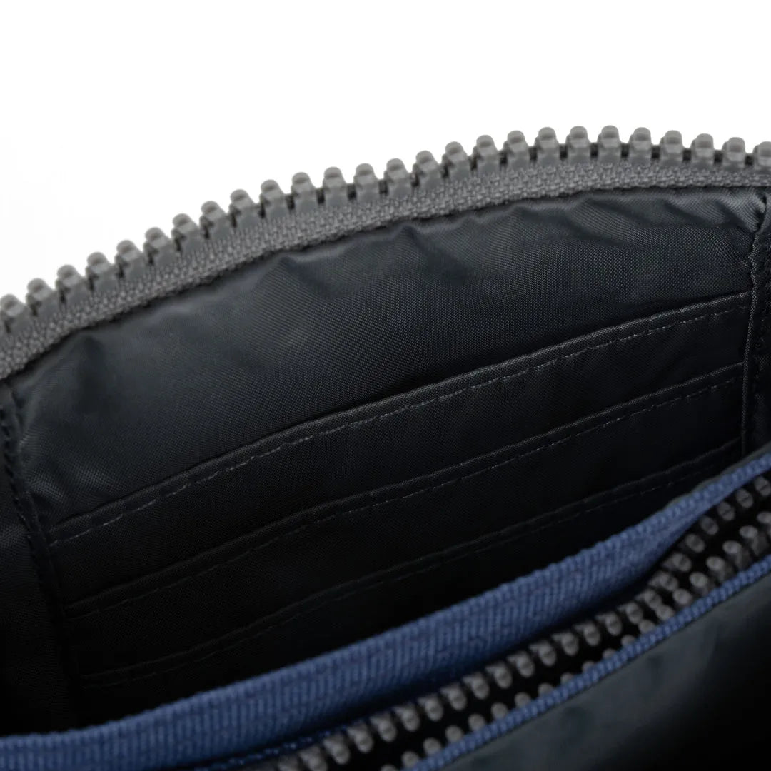 Roka Carnaby burnt blue recycled canvas backpack interior with zippered pocket and multiple card slots.