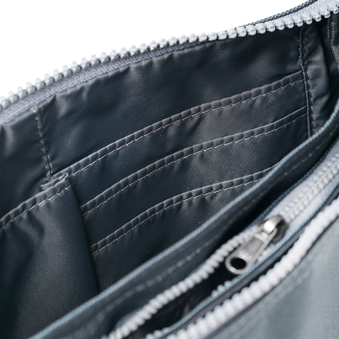 Roka Carnaby Crossbody Smoke XL bag with recycled canvas interior, multiple compartments, and zipper closure.