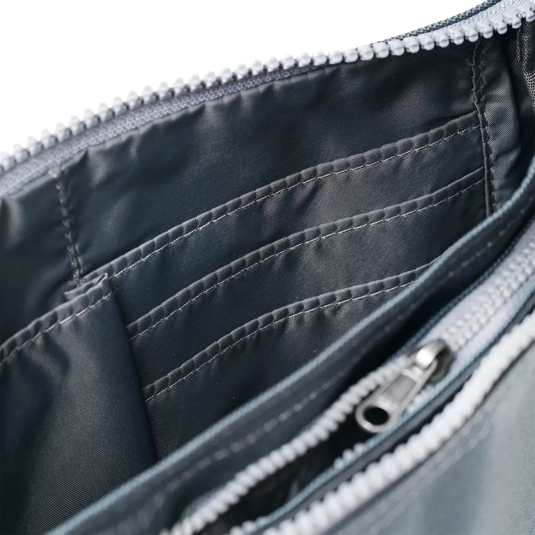 Roka Carnaby Crossbody Smoke XL bag with recycled canvas interior, multiple compartments, and zipper closure.