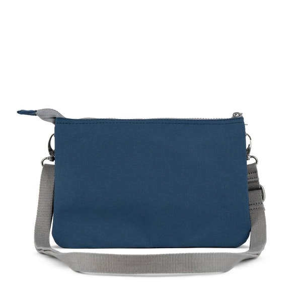 Roka Carnaby Crossbody XL bag in deep blue recycled canvas with adjustable gray strap and silver hardware.