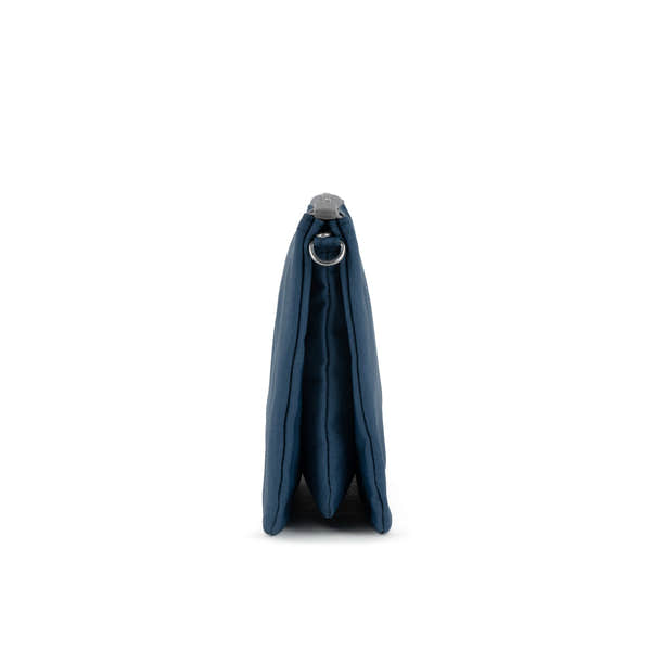 Roka Carnaby Crossbody XL, deep blue recycled canvas bag, side view showing zip closure and metal ring detail.