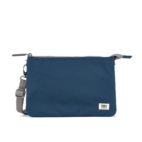 Roka Carnaby Crossbody XL bag in deep blue recycled canvas with adjustable strap and zip closure.