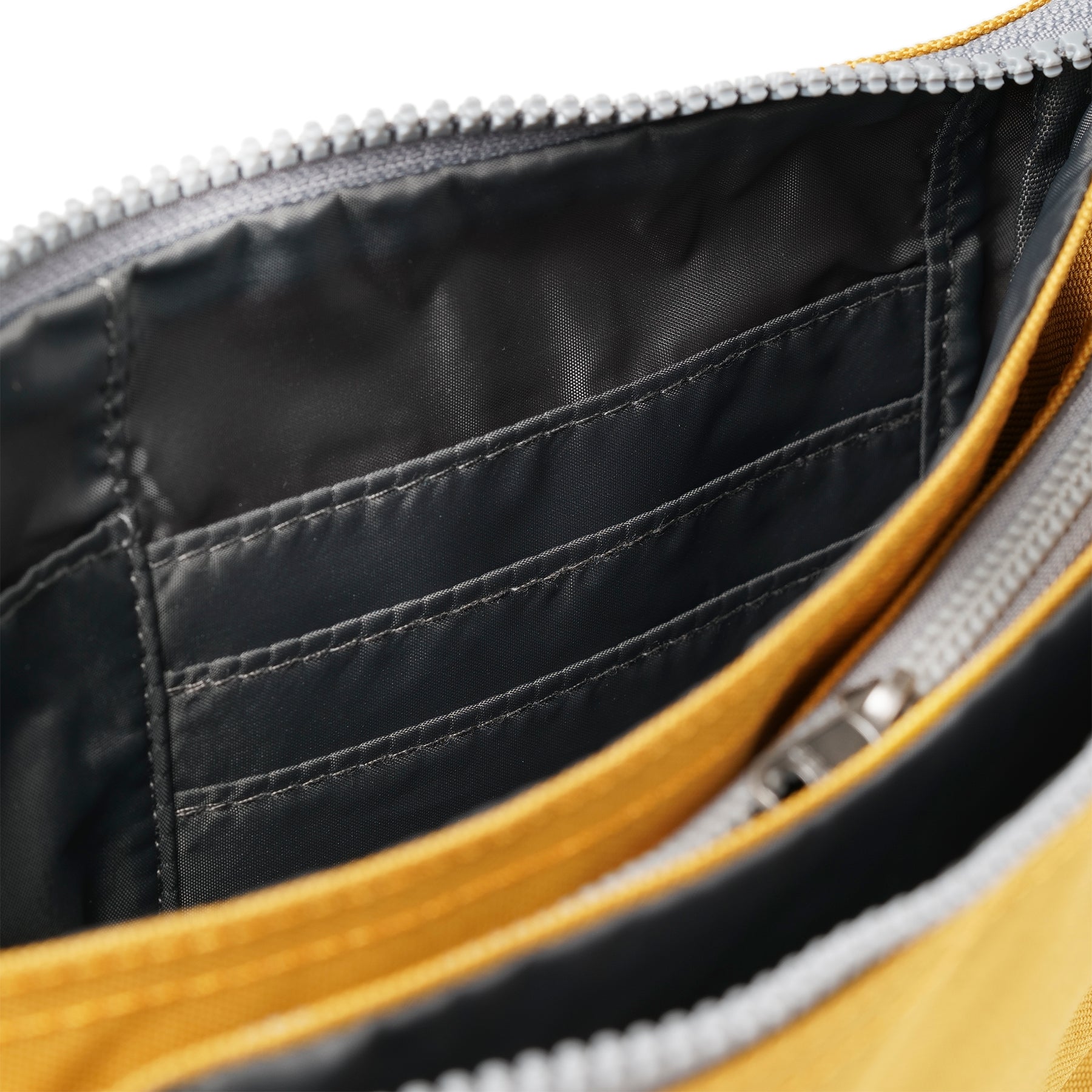Roka Carnaby Crossbody XL bag in flax recycled canvas, with black interior, multiple card slots, and a zippered pocket.