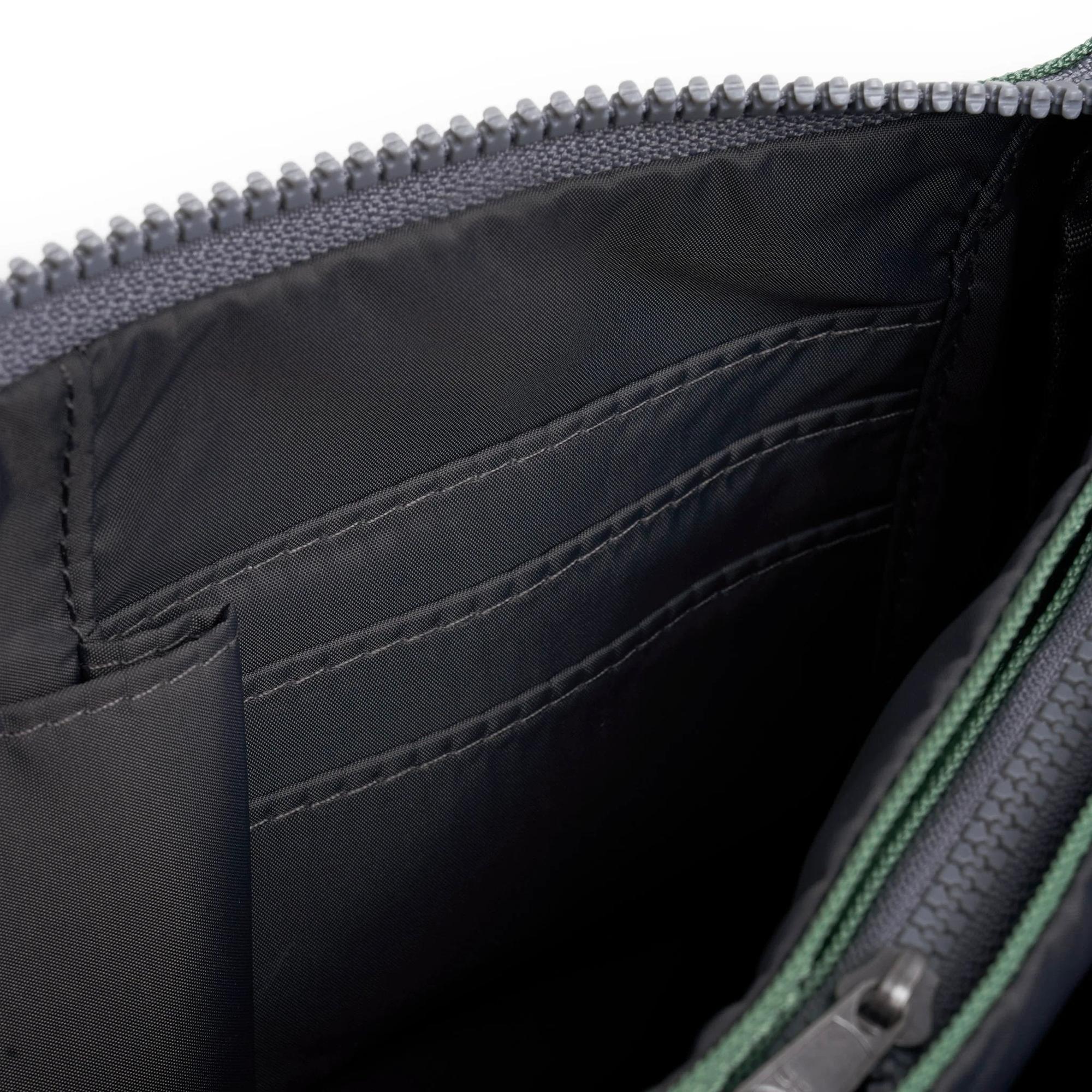 Roka Carnaby Crossbody XL bag in frosted recycled canvas, showing interior with multiple compartments and black lining.