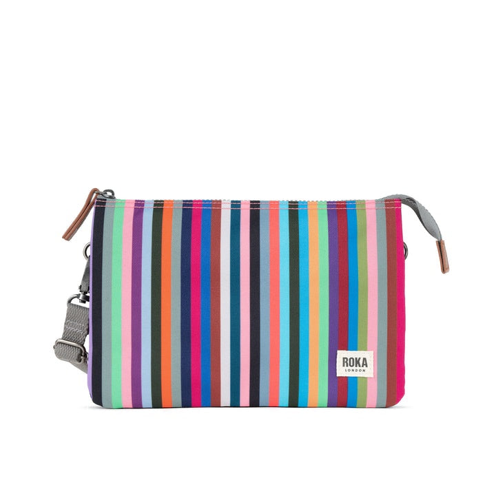 Roka Carnaby Crossbody XL bag with multi-colored stripe recycled canvas, adjustable strap, and zip closure for stylish eco-friendly travel.