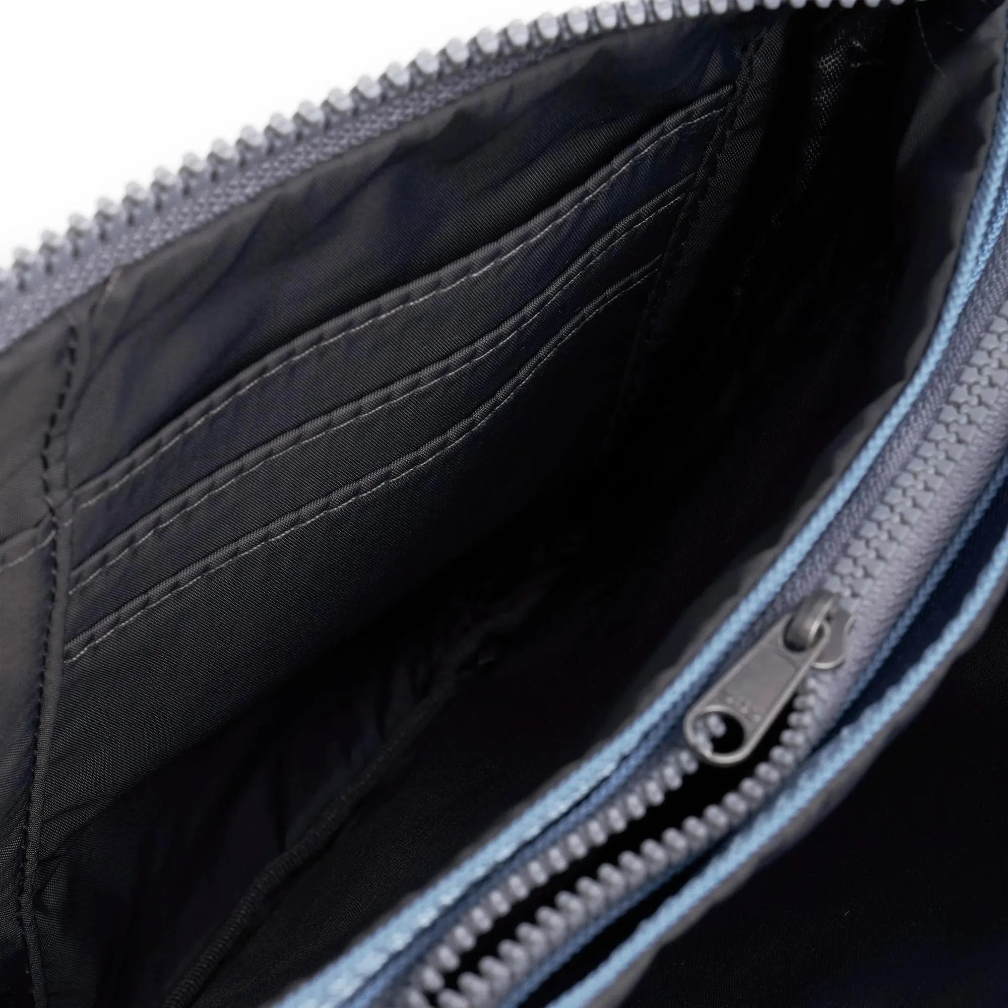 Roka Carnaby Crossbody XL bag in retro blue recycled canvas with spacious interior, multiple compartments, and zipper closure.