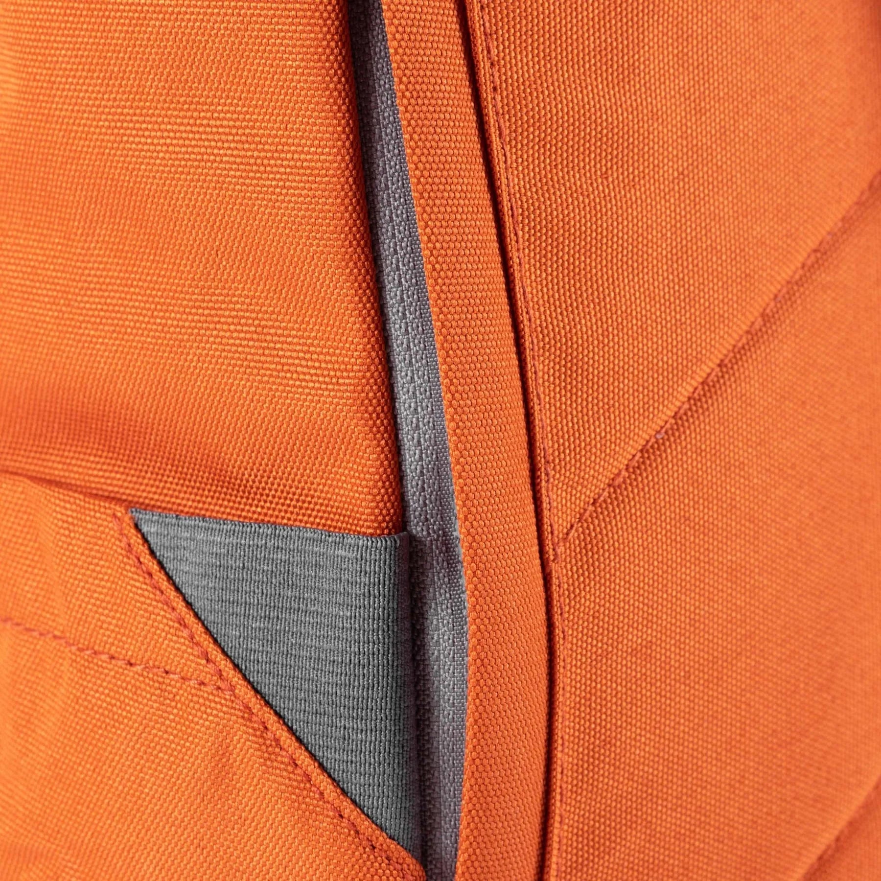 Close-up of an orange Roka Finchley A recycled canvas backpack with gray accents and stitching details.