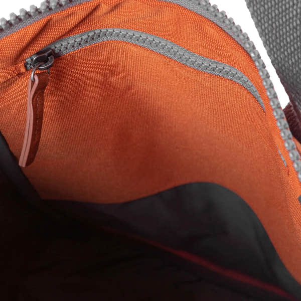 Roka Finchley A Atomic Orange Recycled Canvas backpack interior with zippered pocket and grey zipper detail.