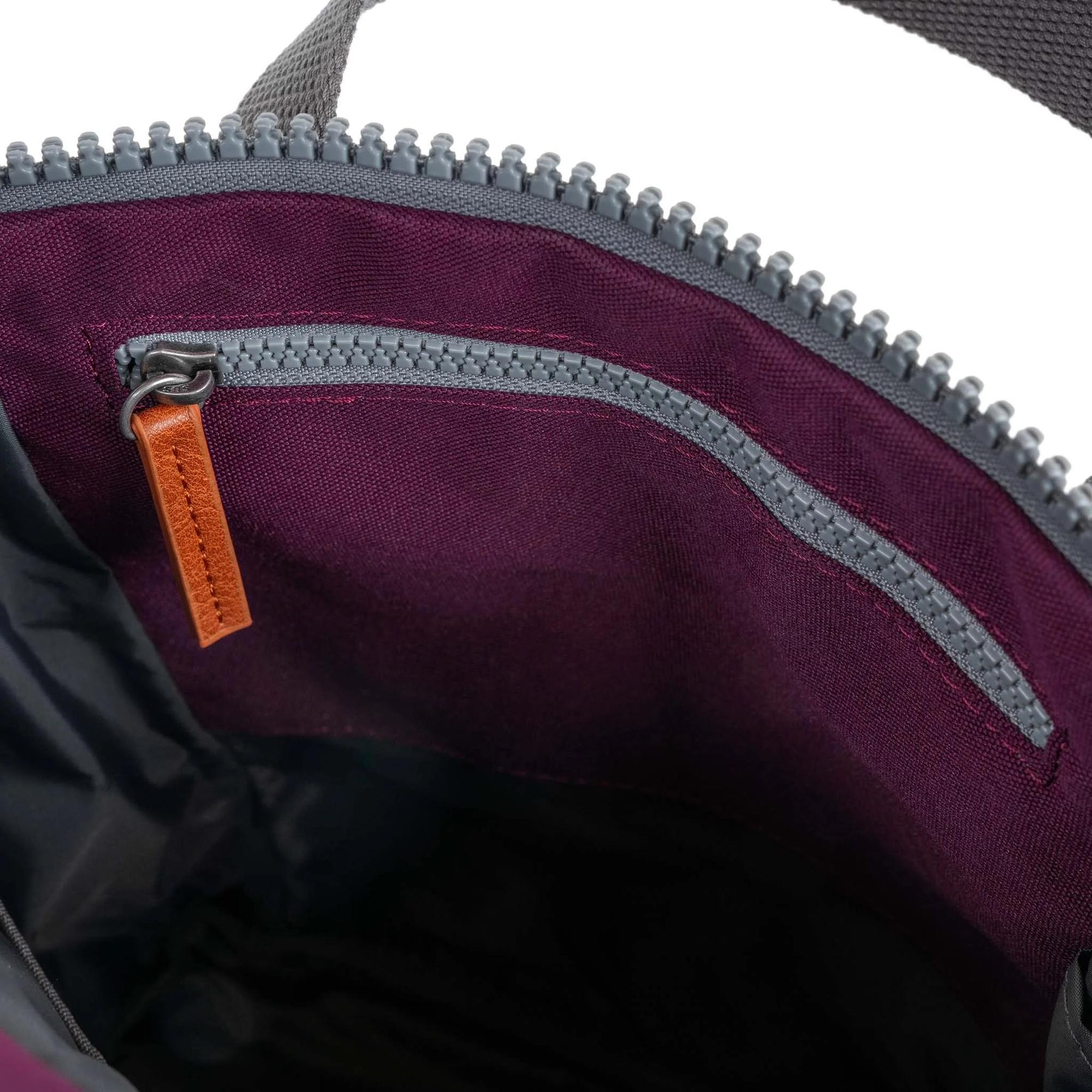 Interior view of Roka Finchley A Cherry Lacquer Recycled Canvas bag with purple lining and grey zipper pocket.