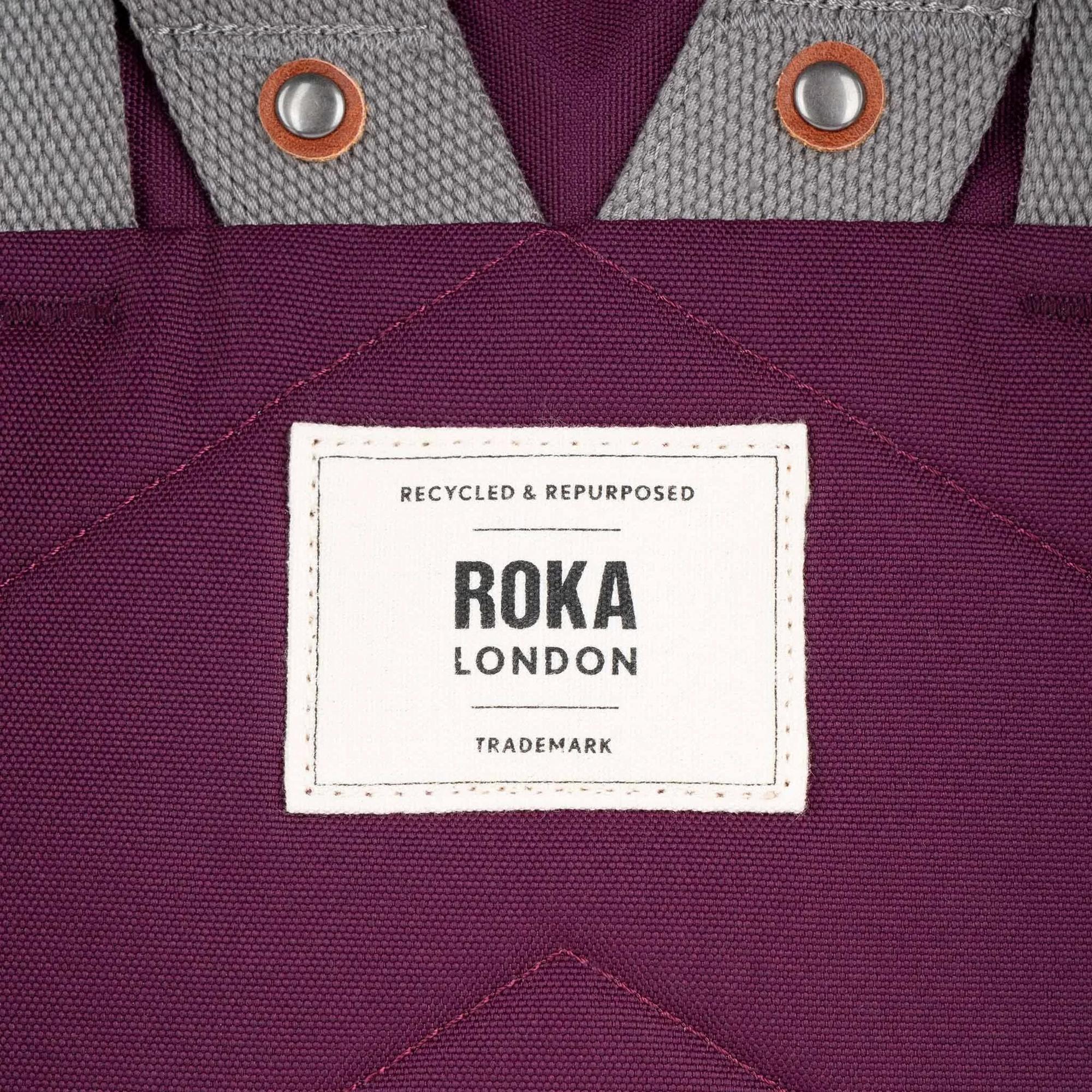Roka London recycled cherry lacquer canvas tote bag with gray fabric accents and metal button details.